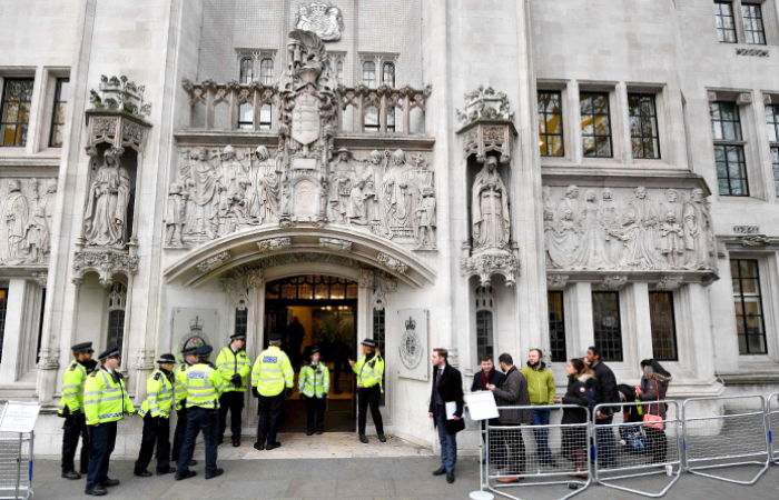 Police officers stand guard outside the Supreme court in London on the second day of a four-day hearing on Tuesday. — AFP