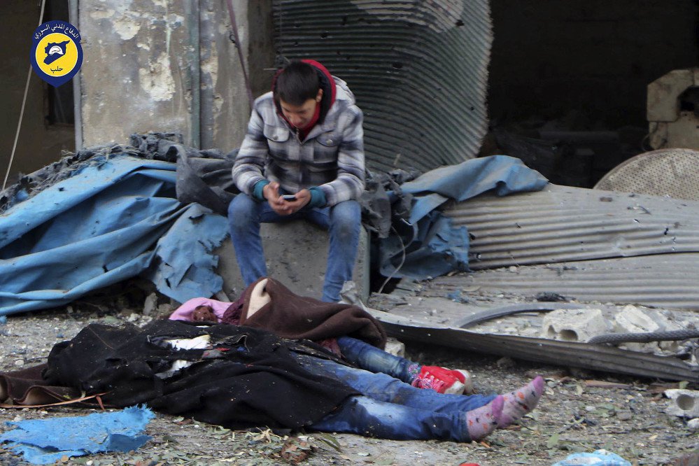 A Syrian boy sits beside bodies after artillery fire struck eastern Aleppo Syria on Wednesday. Fighters on both sides will do anything to gain military advantage a U.N. chief says