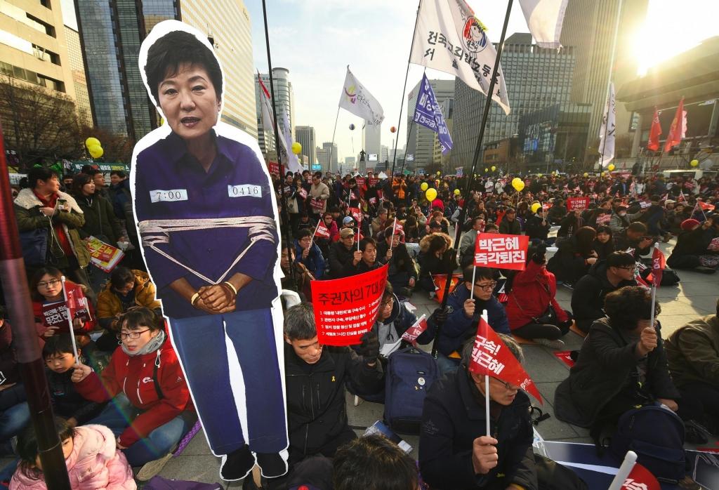 Protesters carry a portrait of South Korea's President Park Geun Hye during a rally against Park in central Seoul on Saturday. Hundreds of thousands of protestors marched in Seoul for the sixth straight week on December 3 to demand the ouster and