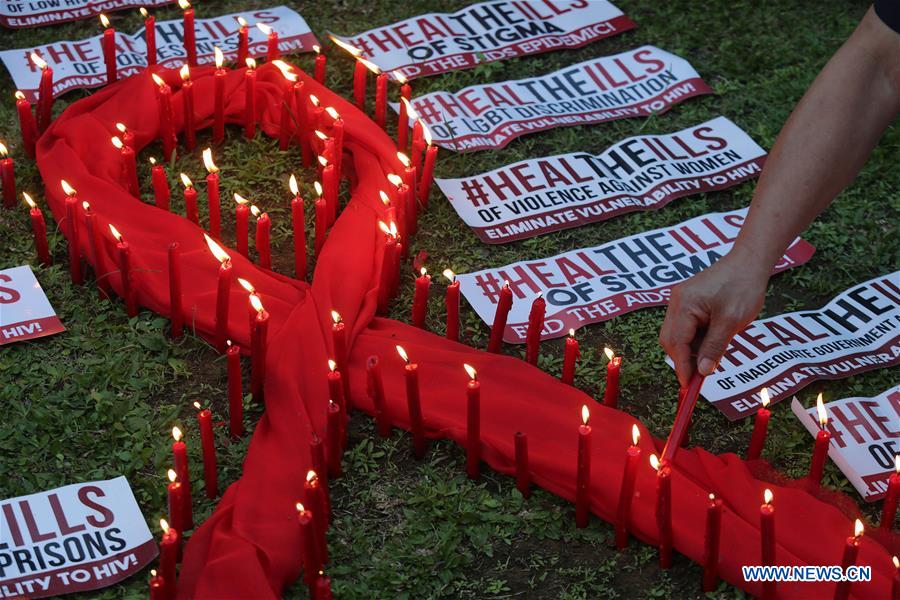 A man lights candles on a red ribbon-shaped cloth in observance of the World AIDS Day in Quezon City the Philippines Dec. 1 2016. People around the world are observing the World AIDS Day to raise awareness and prevention on HIV  AIDS. (Xinhua  Rouelle Um