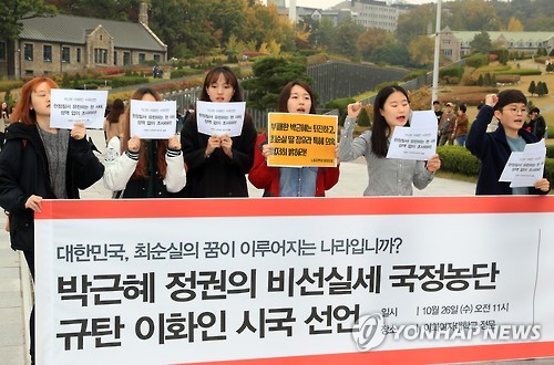 A group of students at Ewha Womans University in Seoul calls for a thorough investigation into allegations Choi Soon-sil a close friend of President Park Geun-hye meddled in state affairs using her ties to the president at the school's front gate on Oc