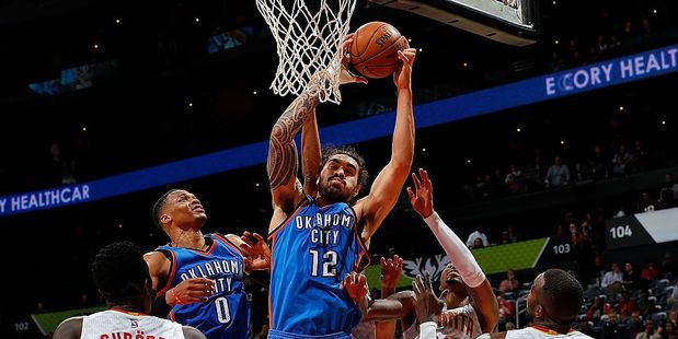 Steven Adams of the Oklahoma City Thunder and teammate Russell Westbrook fight for a rebound against the Atlanta Hawks