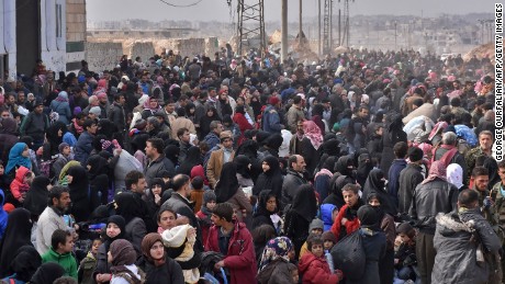 Syrians flee from eastern Aleppo on Tuesday lining up to get onto government buses