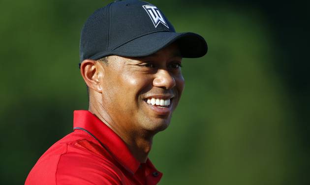 Tiger Woods stands on the 18th green during the trophy ceremony for Quicken Loans National PGA golf tournament winner Billy Hurley III in Bethesda Md. Tiger Woods returns to competition and Ernie Els is more cur