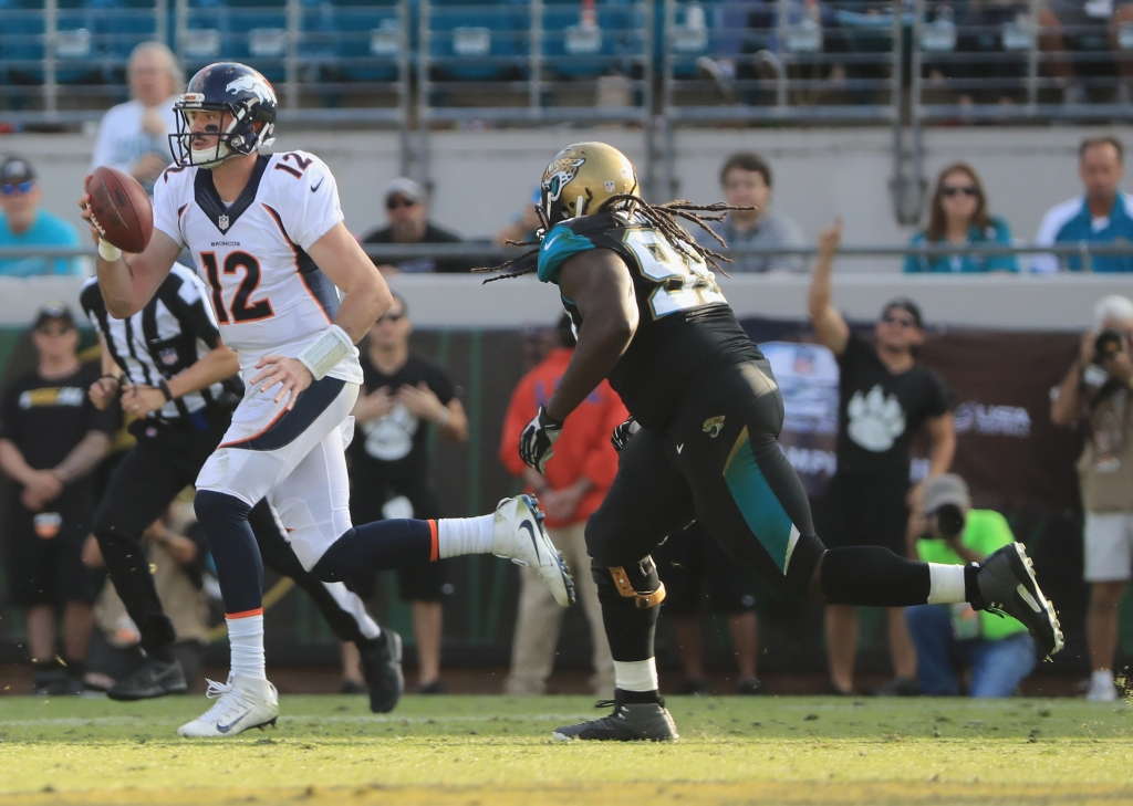 Paxton Lynch of the Denver Broncos runs for yardage as Sen'Derrick Marks #99 of the Jacksonville Jaguars pursues at Ever Bank Field