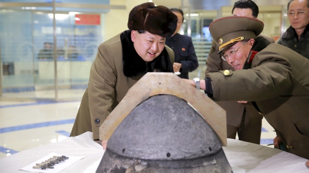 North Korean leader Kim Jong-un looks at a rocket warhead tip after what the country's Korean Central News Agency said was a simulated test of atmospheric re-entry of a ballistic missile at an unidentified location in this undated file