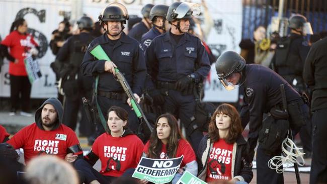 Police prepare to arrest protesters calling for a minimum wage of $15 an hour during a demonstration in Los Angeles California