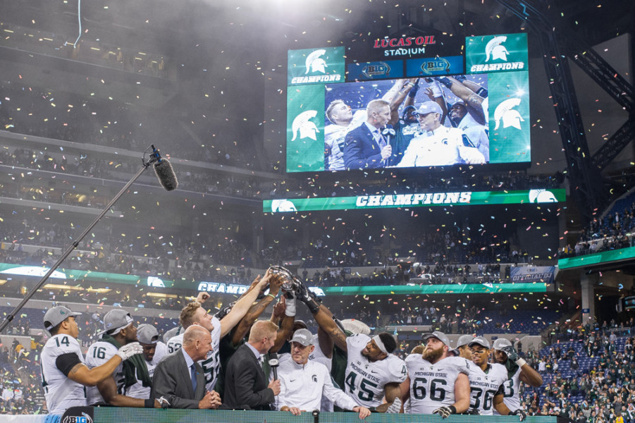 The Michigan State team celebrates winning the Big 10 championship game between the Michigan State Spartans and Iowa Hawkeyes at Lucas Oil Stadium in Indianapolis IN