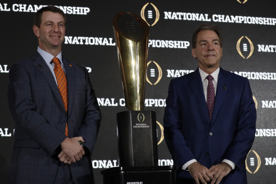 Clemson head coach Dabo Swinney and Alabama head coach Nick Saban pose with the championship trophy during a news conference for the NCAA college football playoff championship game Sunday Jan. 8 2017 in Tampa Fla