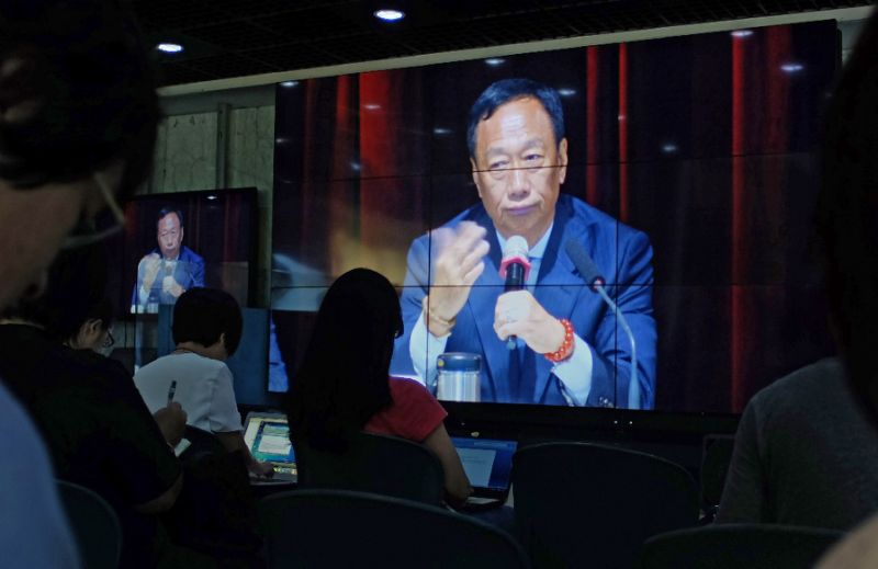 Journalists watch a large video screen showing Terry Gou founder of Foxconn parent Hon Hai group during a shareholders conference at the company's headquarters in Tucheng in New Taipei City