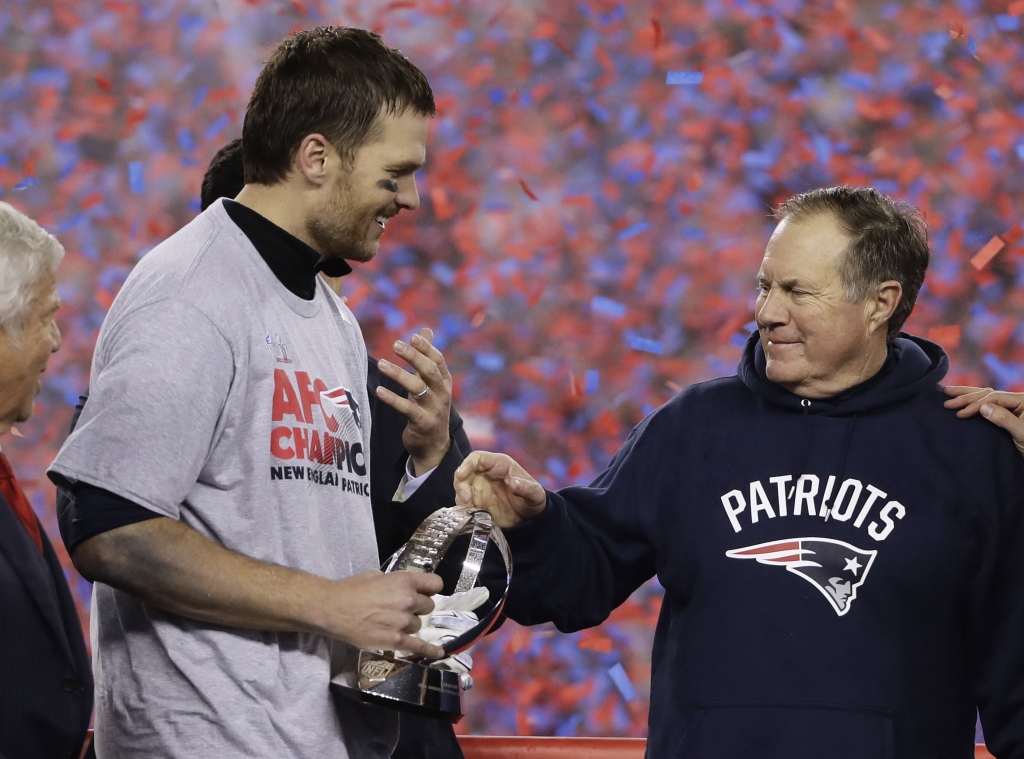 New England Patriots quarterback Tom Brady left holds the AFC Championship trophy as he celebrates with head coach Bill Belichick after the AFC championship NFL football game Sunday Jan. 22 2017 in Foxborough Mass. The Patriots defeated the the Pi