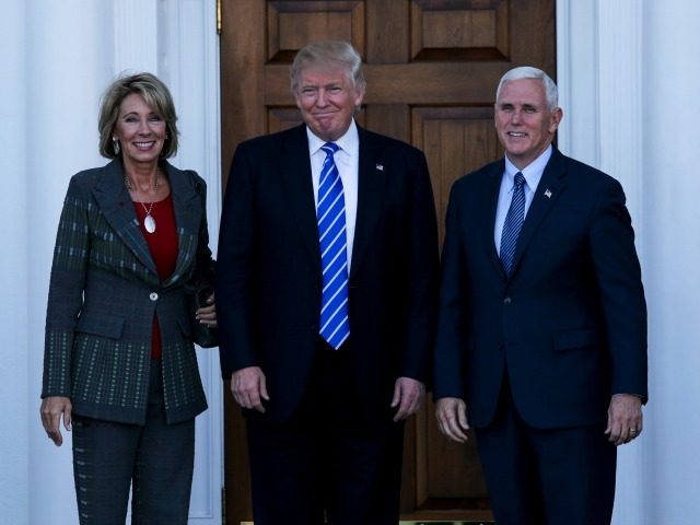 United States President-elect Donald Trump and Vice President-elect Mike Pence pose with Betsy De Vos at the clubhouse of Trump International Golf Club