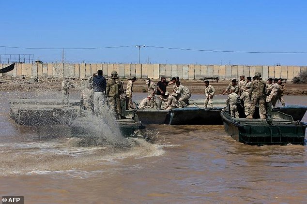 International coalition forces and Iraqi soldiers instal a floating bridge at the Taji camp north of Baghdad during a training session ahead of installing replacement bridges in Mosul