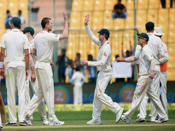 Josh Hazlewood celebrates with teammates after picking Virat Kohli's wicket