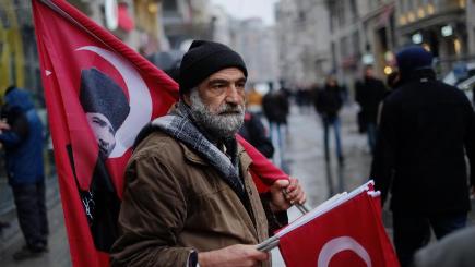 A vendor holds Turkish flags for sale during a protest outside the Dutch consulate in Istanbul