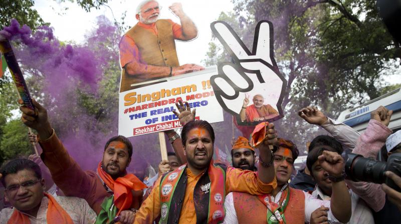 Bharatiya Janata Party supporters celebrate as their party leads in Assembly elections in Uttarakhand and Uttar Pradesh