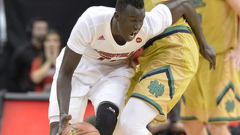 Louisville's Deng Adel attempts to fight through the screen set by Notre Dame's Martinas Geben during the first half of an NCAA college basketball game Saturday