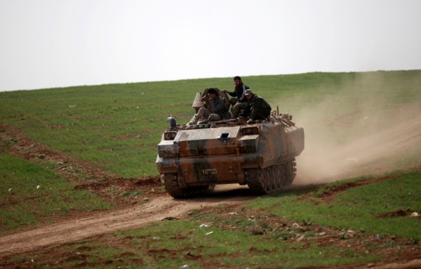 Rebel fighters ride a military vehicle east of al Bab town Syria