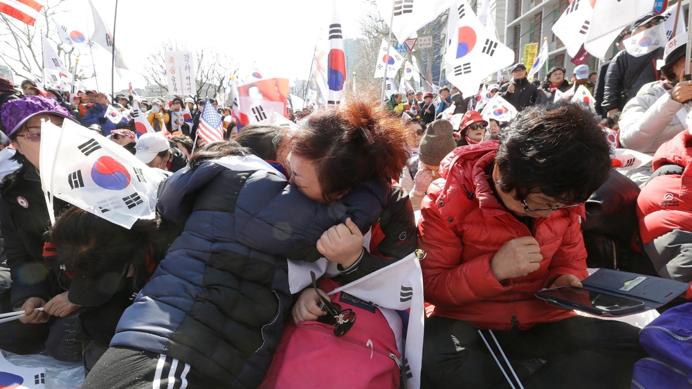 Supporters of South Korean President Park Geun-hye weep during a rally opposing her ouster on Friday