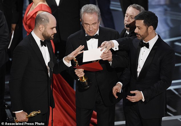 'La La Land producer Jordan Horowitz left presenter Warren Beatty center and host Jimmy Kimmel right look at an envelope announcing'Moonlight as best