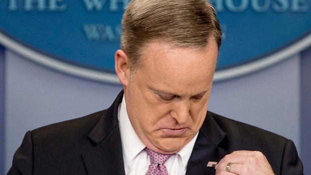 White House press secretary Sean Spicer adjusts his American flag pin after he was told that it was upside down on Friday during the daily press briefing at the White House in Washington D.C