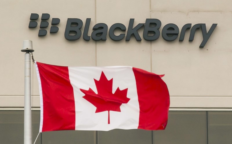 A Blackberry logo hangs behind a Canadian flag at their offices on the day of their annual general meeting for shareholders in Waterloo Canada