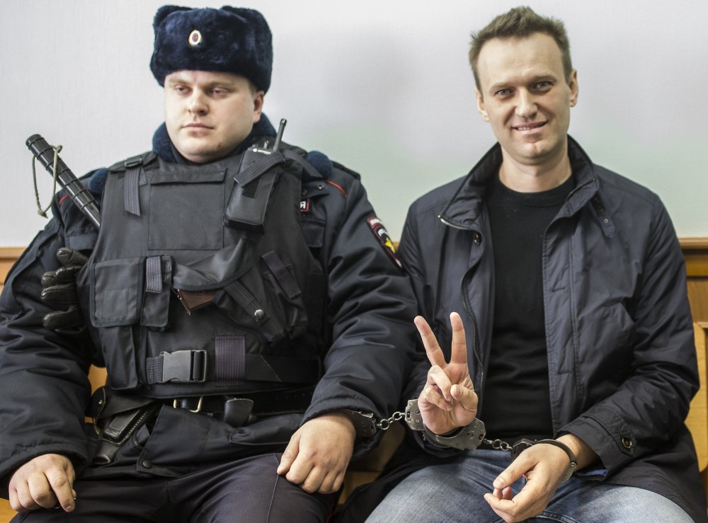 Opposition leader Alexei Navalny handcuffed to a guard in court in Moscow. Navalny is serving 15 days on charges of resisting police