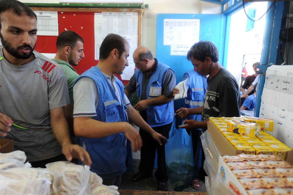 UNRWA staff distributing food to displaced families in various UNRWA shelters in Gaza City