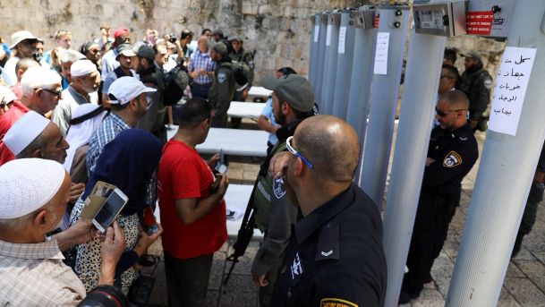 Muslim worshipers stand in front of Israeli policemen and newly installed metal detectors at an entrance to the compound known to Muslims as Noble Sanctuary and to Jews as Temple Mount in Jerusalem's Old City