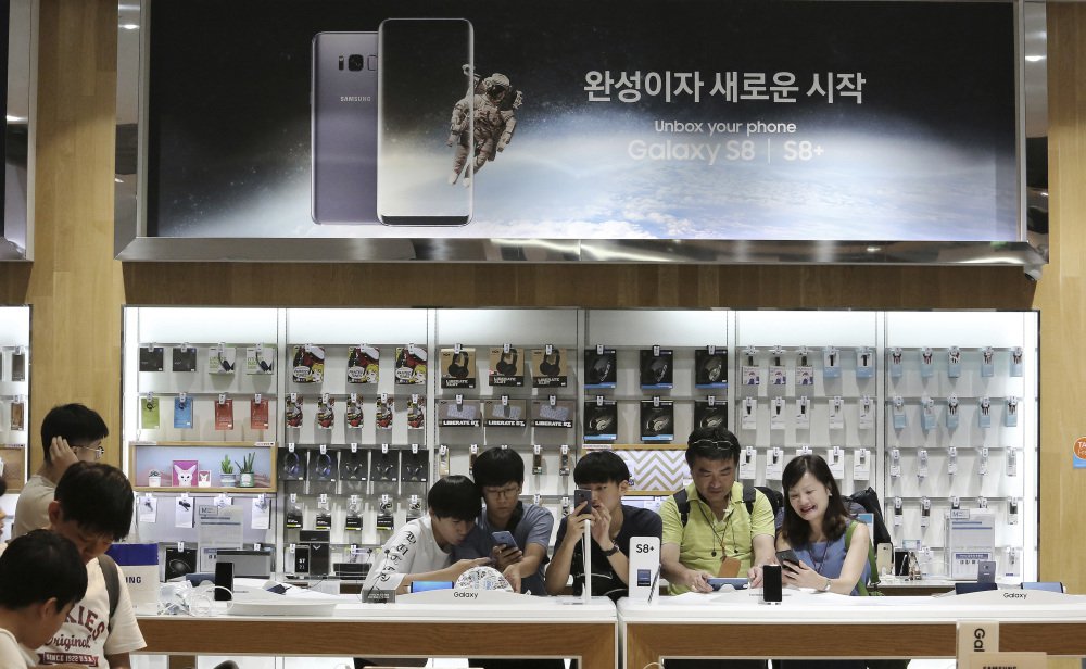 Visitors experience the Samsung Electronics Galaxy S8 Plus smartphone at one of the company's stores in Seoul South Korea. The tech company said Friday its second-quarter operating profit soared to the highest in its history