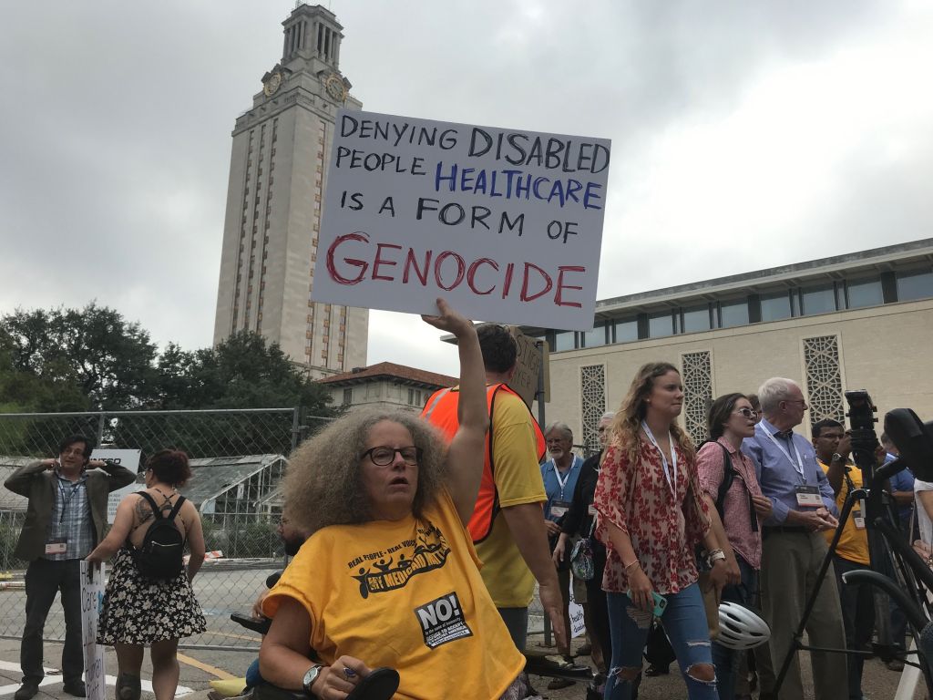 A woman Stephanie Thomas from the group ADAPT carries a poster as part of a protest against the Republican Health Care bill