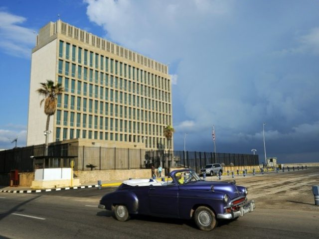 A vintage car drives by the US Embassy in Havana which Secretary of State Rex Tillerson has said could be closed over mysterious attacks on American diplomats