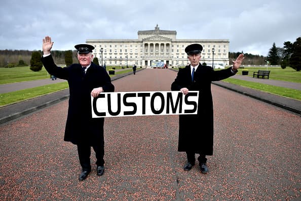 Two men dressed as customs officers take part in a protest outside Stormont against Brexit