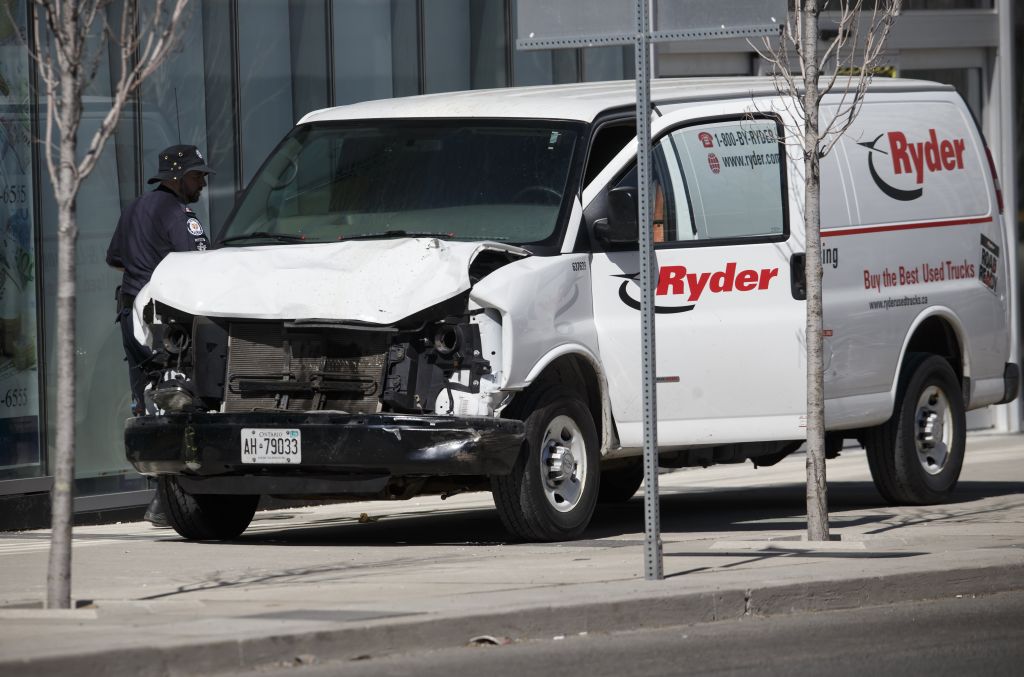 Police inspect a van suspected of being involved in a crash that injured multiple pedestrians
