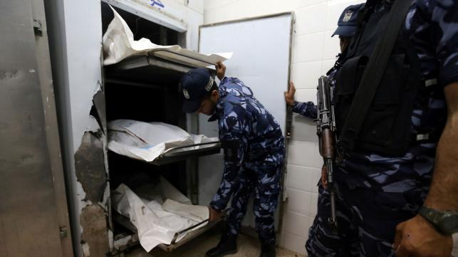 Palestinian Hamas police officers stand next to the bodies of Hamas gunmen who were killed in an explosion at a hospital morgue in the central Gaza Strip on 5 May 2018. Reuters