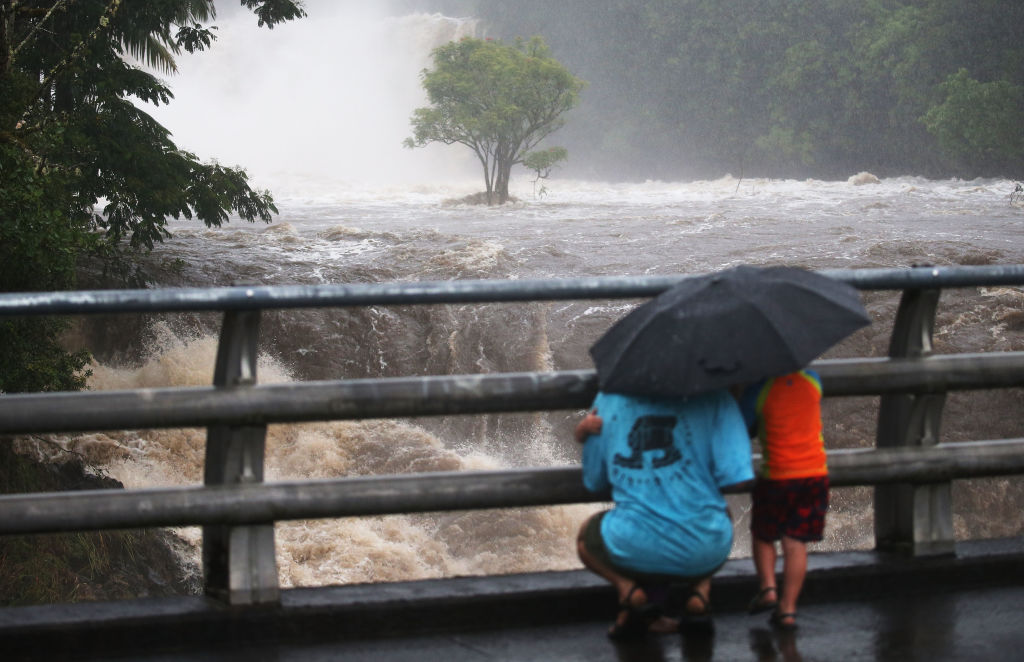 People gather on a bridge to watch the Wailuku River in flood on Hawaii's Big Island