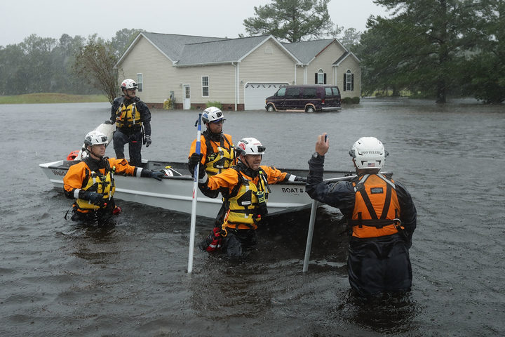 Members of the FEMA Urban Search and Rescue Task Force 4 from Oakland California search a flooded neighborhood for evacuees during Hurricane Florence in Fairfield Harbour North Carolina